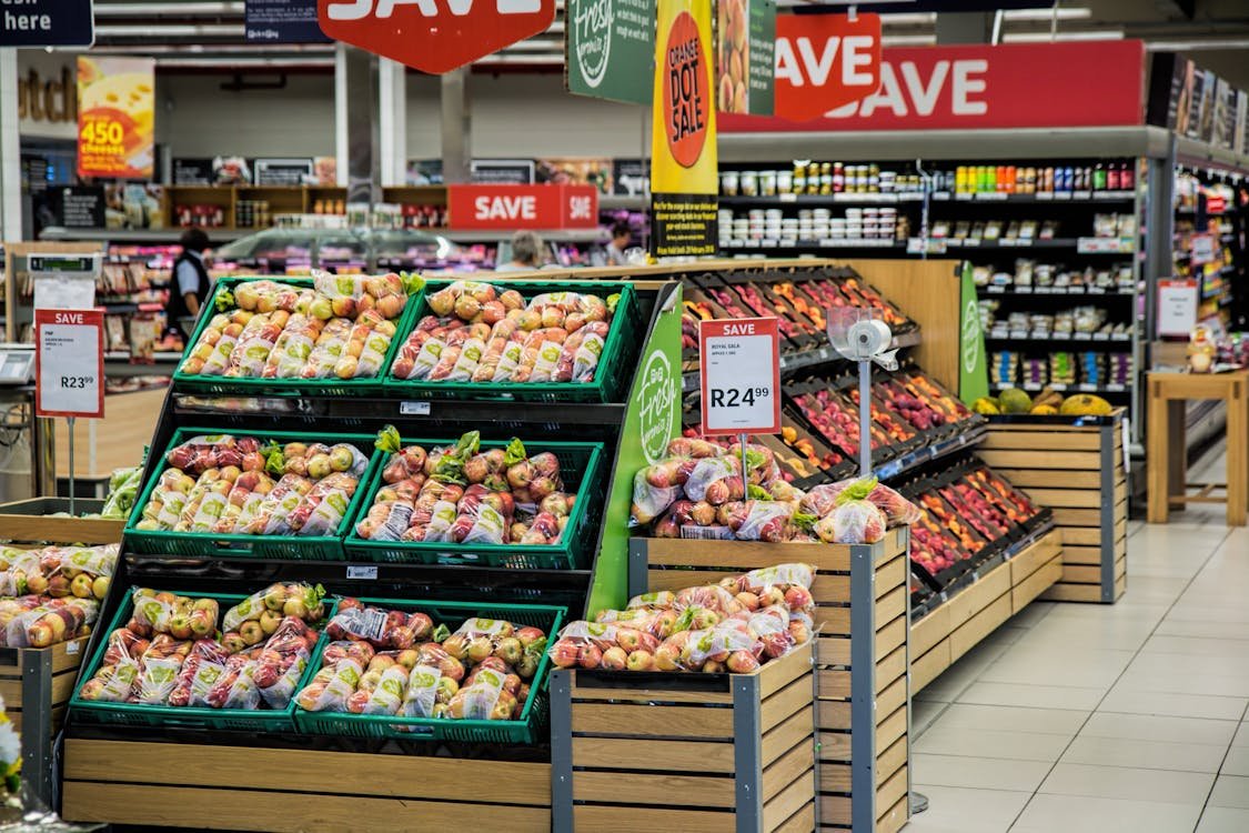 Fresh produce display in a supermarket with various discounts and promotions, highlighting Food City Ad Next Week.