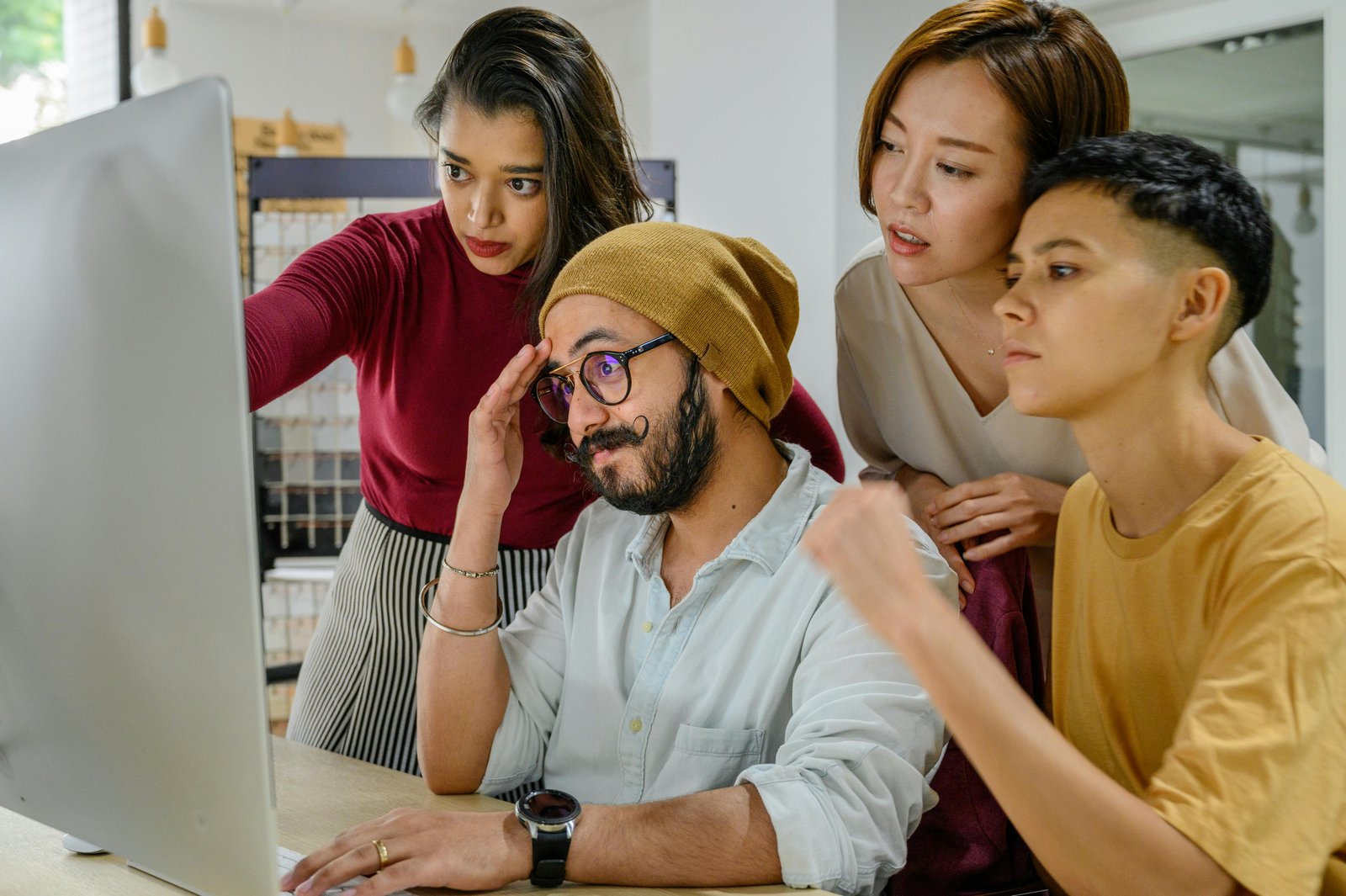 A diverse group of entrepreneurs collaborating on a computer, discussing strategies in a free market economy.