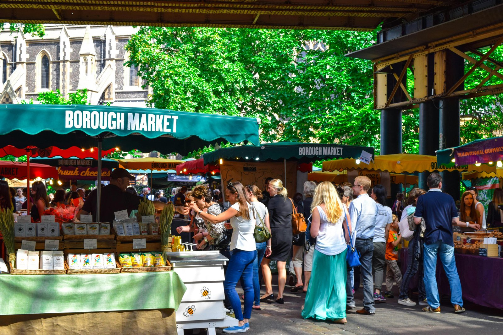 Busy outdoor market scene demonstrating capitalism for economic growth with diverse vendors and shoppers.