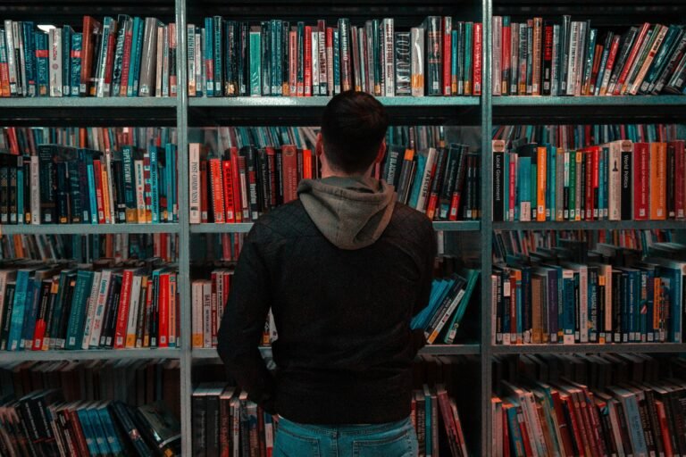 a man standing in front of a shelf of books - woke political ideology