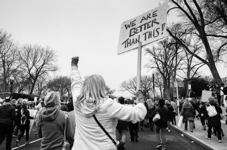 a woman holding up a sign at a protest - Censorship and Freedom of Speech