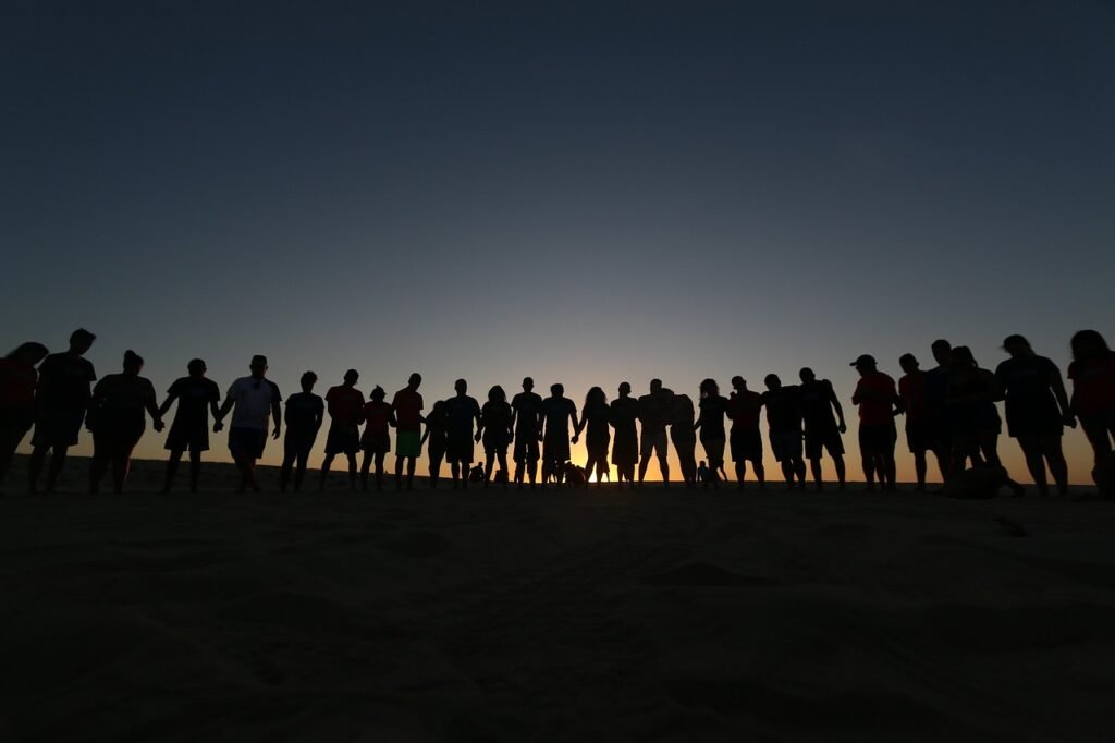 a group of people standing in the sand - a group of people sitting at a table - Freedom of Speech by Country Rank