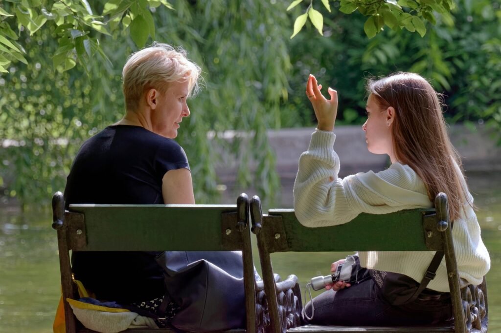 two women sitting on a bench talking - woke political movement