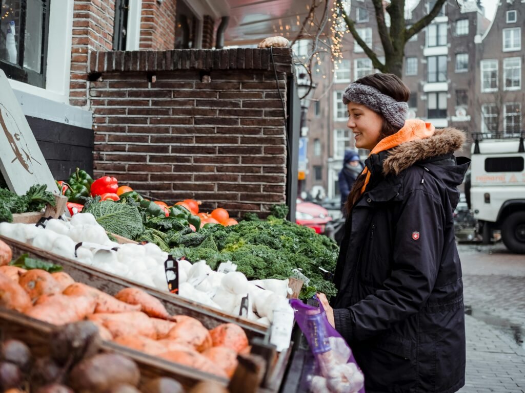 Woman Standing in Front of Vegetable Stall - support local economy