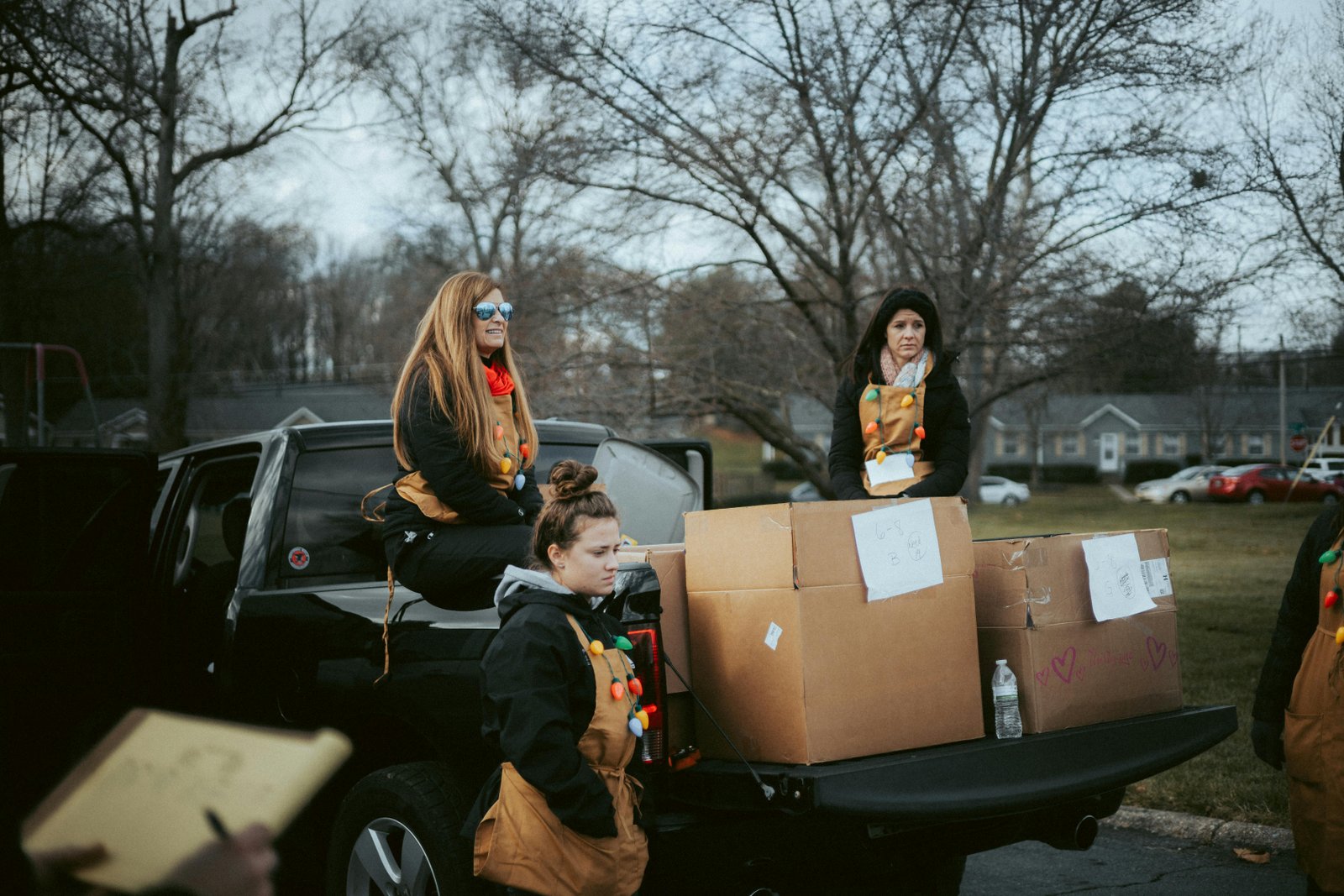 Volunteers from organizations that give back to the community unload donations from a truck.