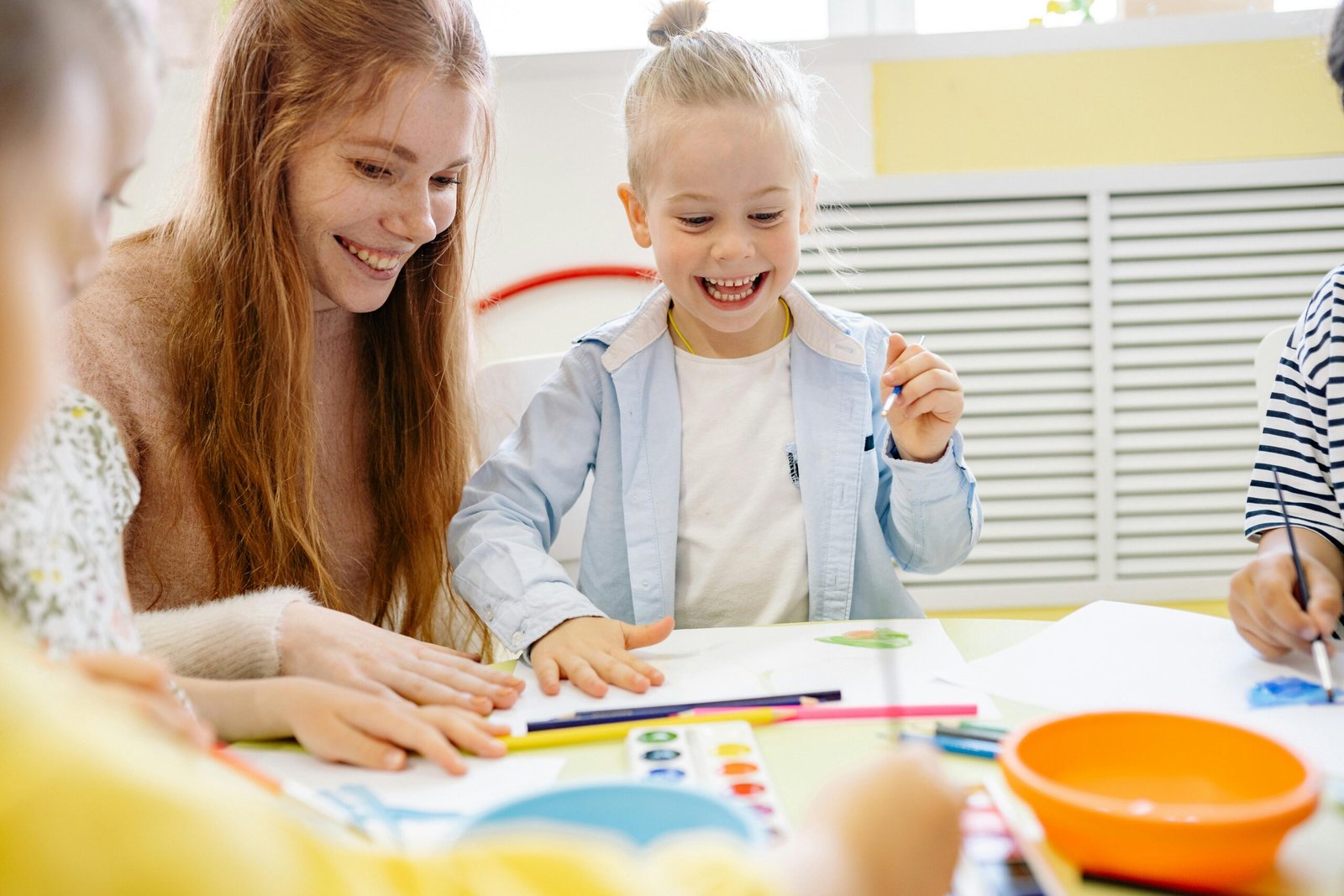 A child and teacher enjoying a painting session as part of kid-friendly activities.