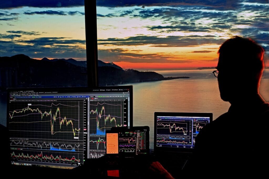 a man looking at multiple computer screens to check stock market - Laissez faire economics vs socialism