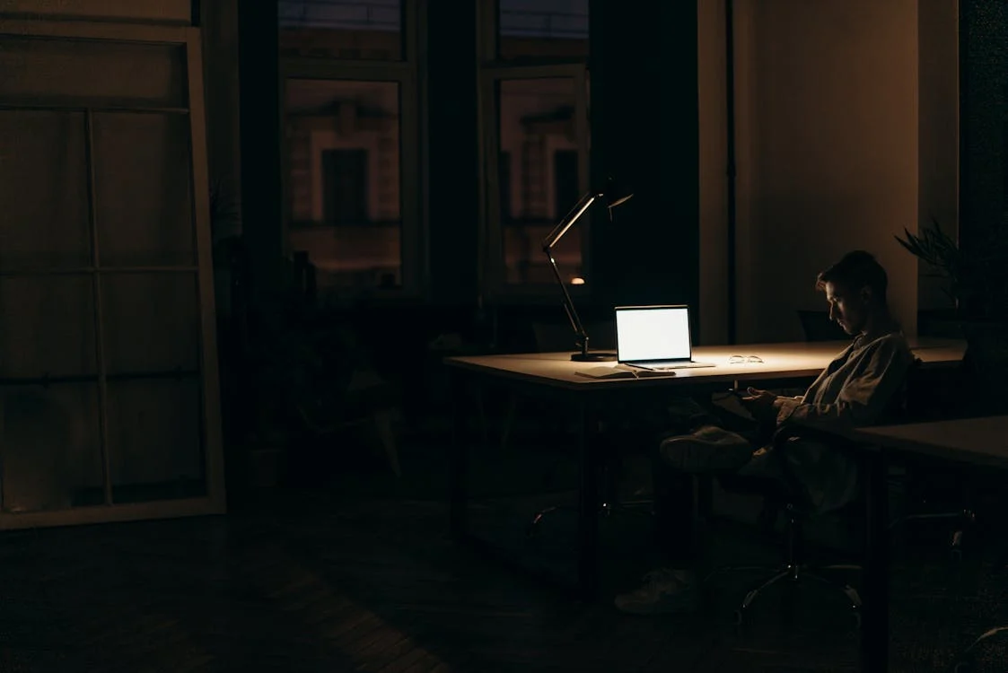 Person working late in dimly lit office, illustrating Fair Labor Standards Act's Overtime Compensation.