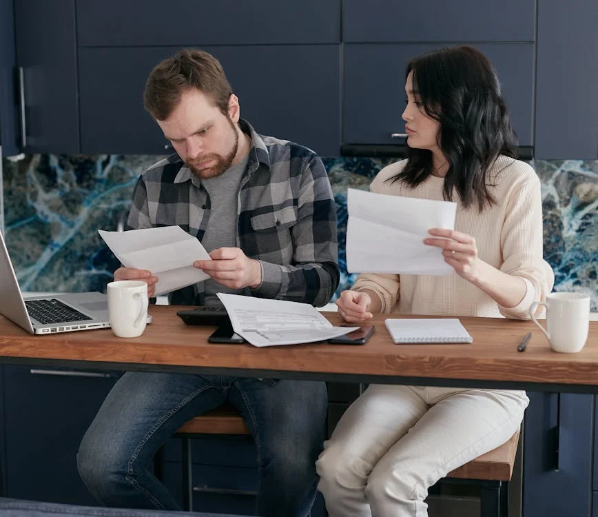 Couple reviewing financial documents at home, discussing Types of Risks in Risk Management.