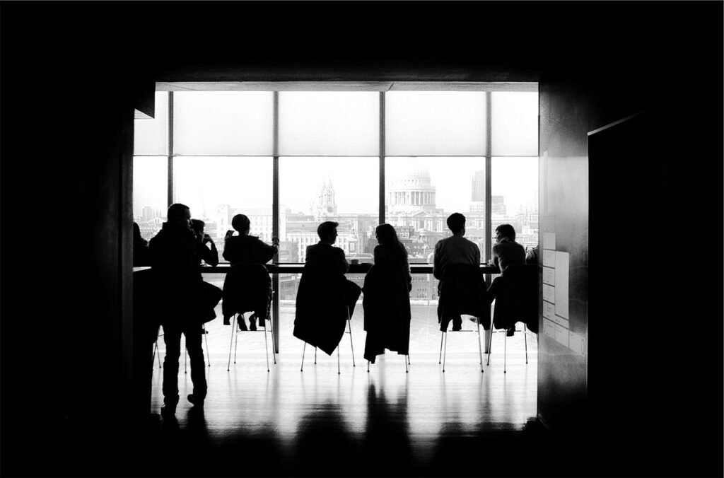 people sitting at a table looking out a window - stages of business growth