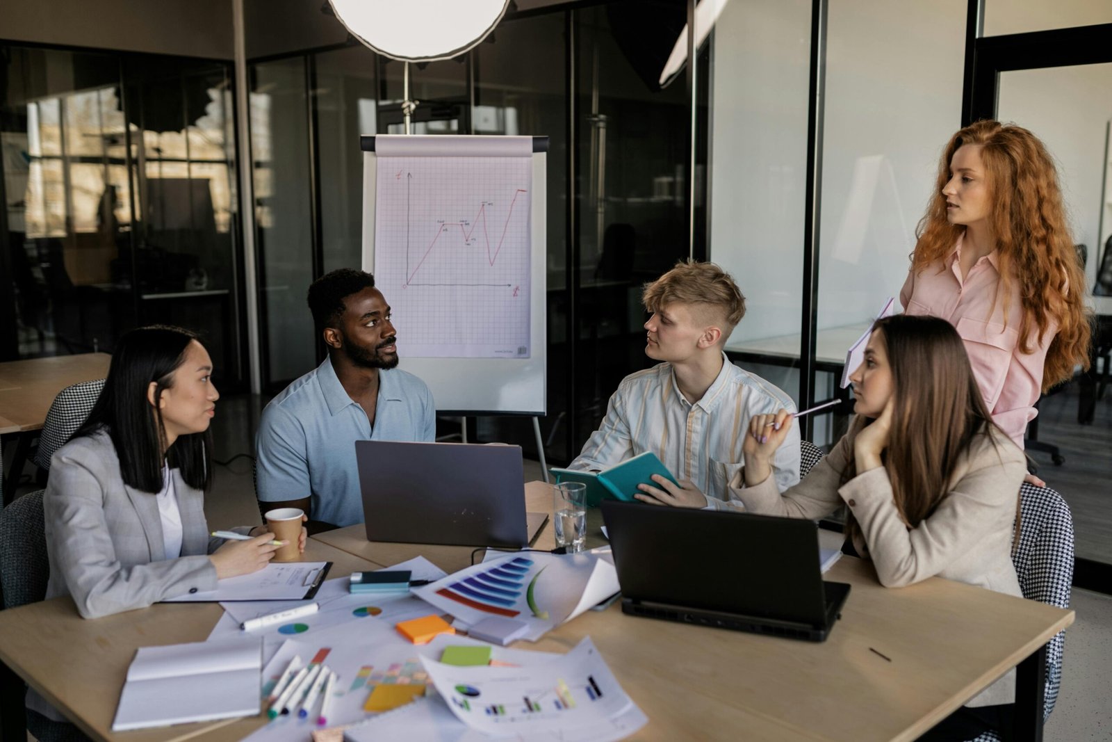 Group of professionals in a meeting discussing business strategies, highlighting 'Business Development vs Marketing' differences.