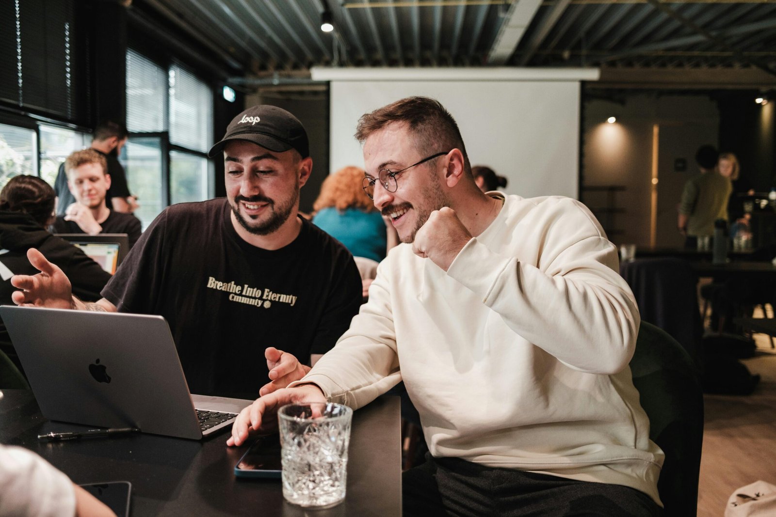 Two colleagues collaborating on a laptop, discussing Fair and Equitable Compensation.