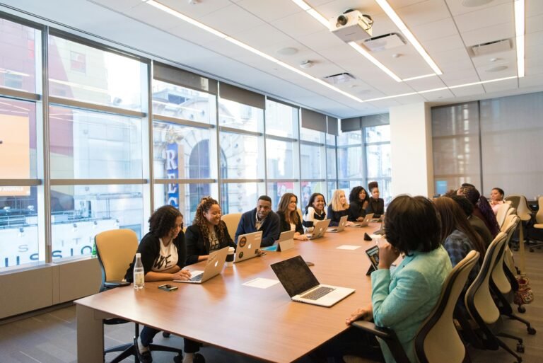 a group of people sitting around a table with laptops - good corporate governance