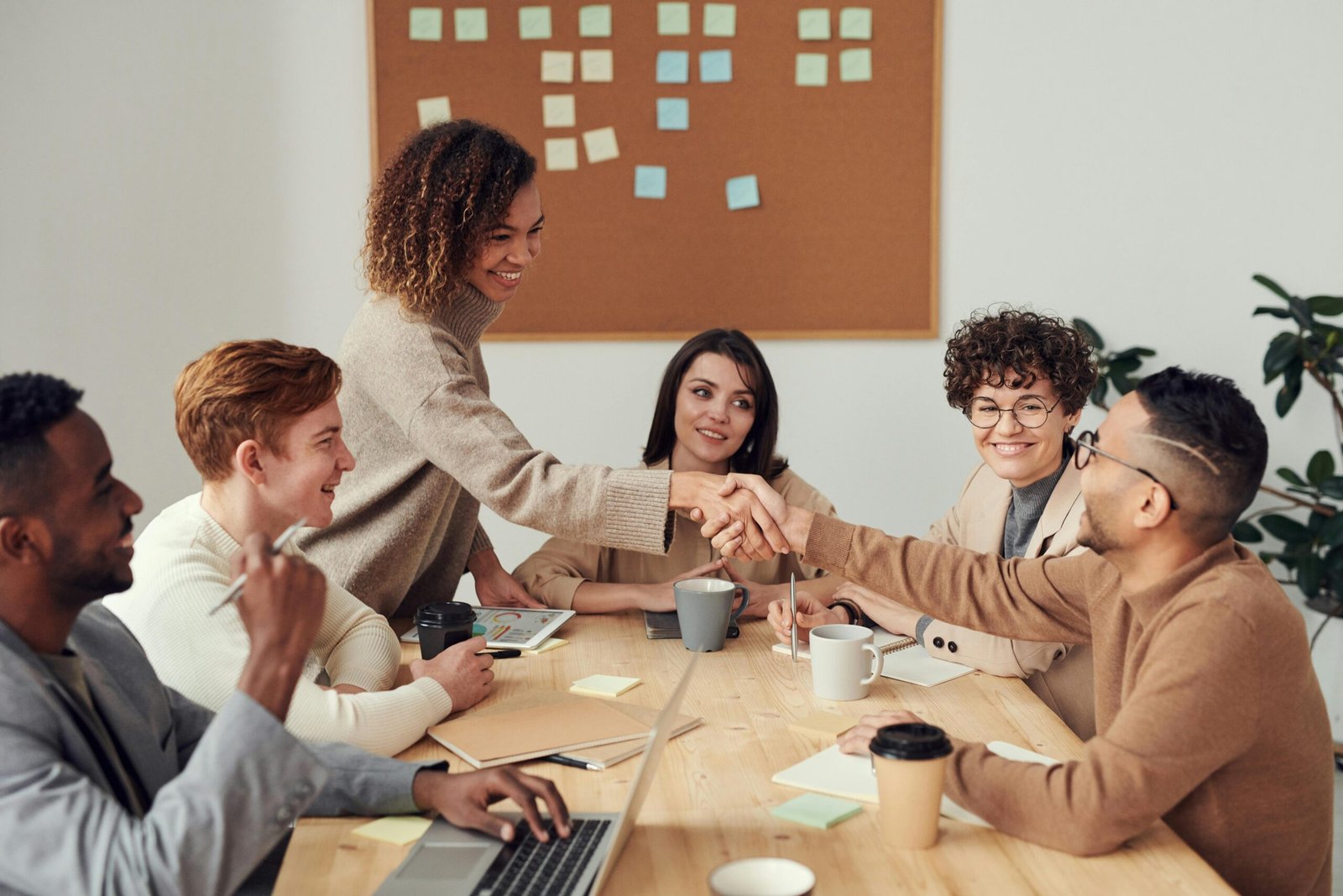 a group of people around a table - What are cross functional teams