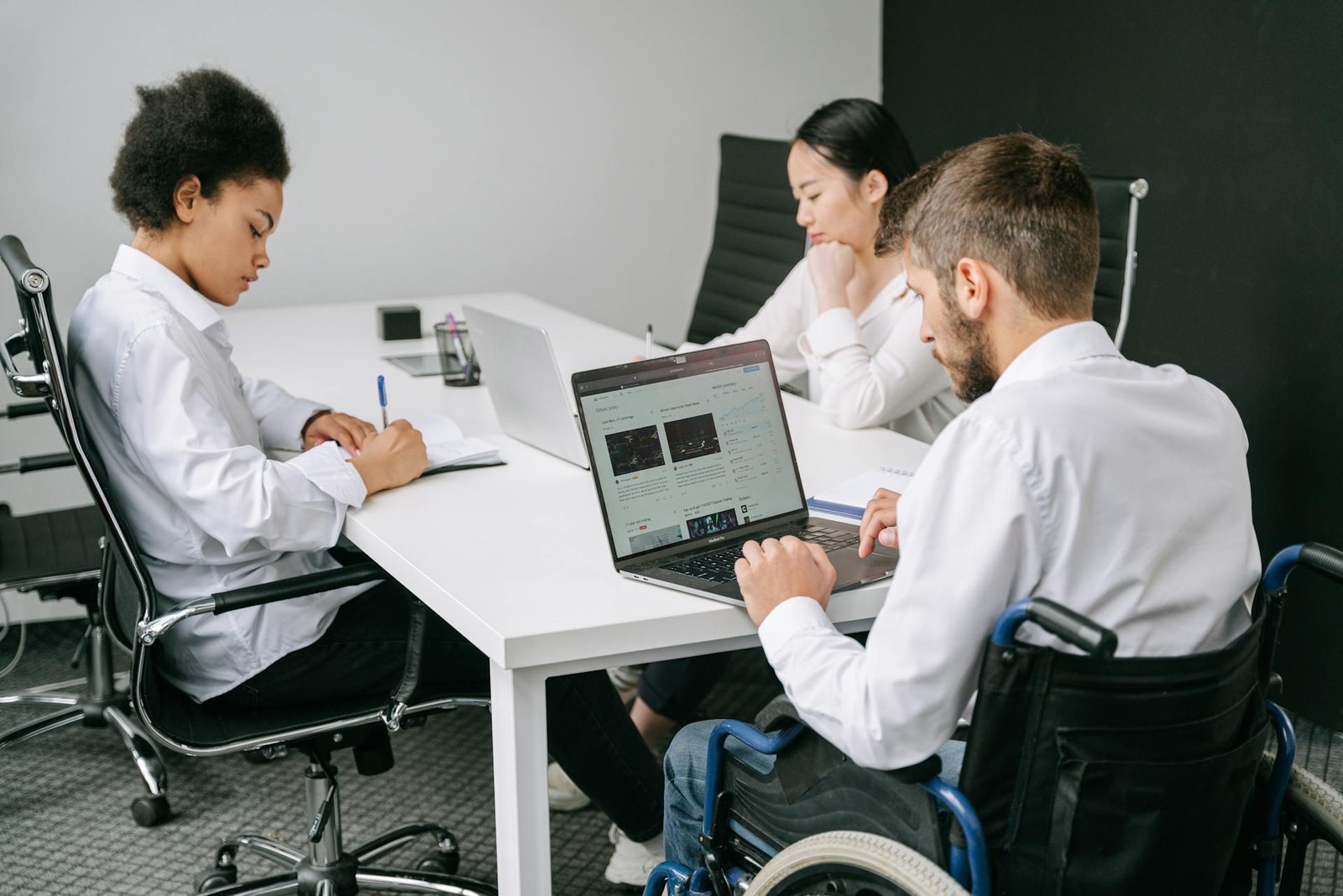 a group of people sitting at a table with a laptop - growth strategies for business