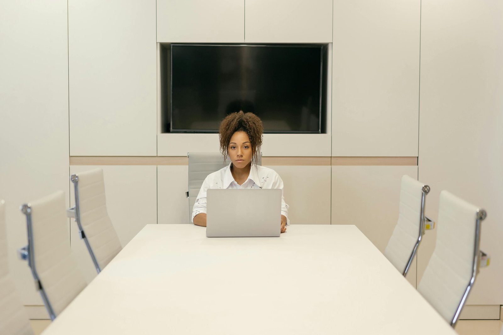 Focused woman working alone in a modern conference room, representing an Equal Opportunity Employer