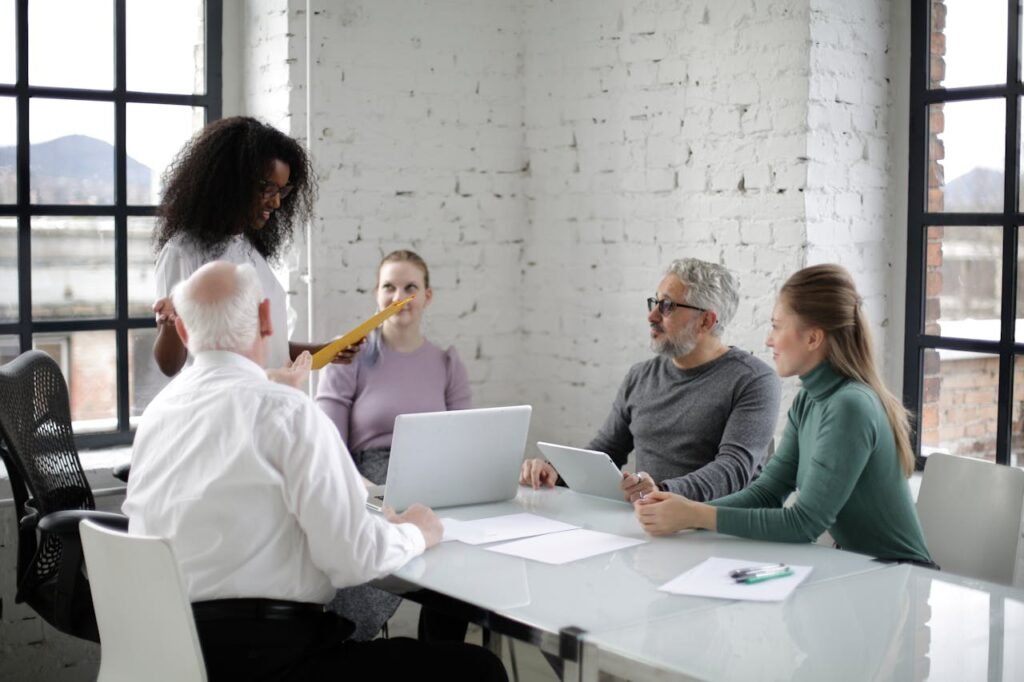 a woman standing in front of a group of people - challenges of cross-functional teams