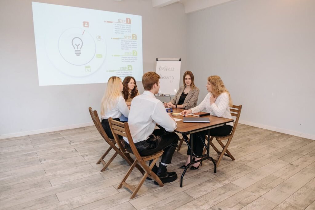 a group of people sitting at a table - Growth Strategies for Business