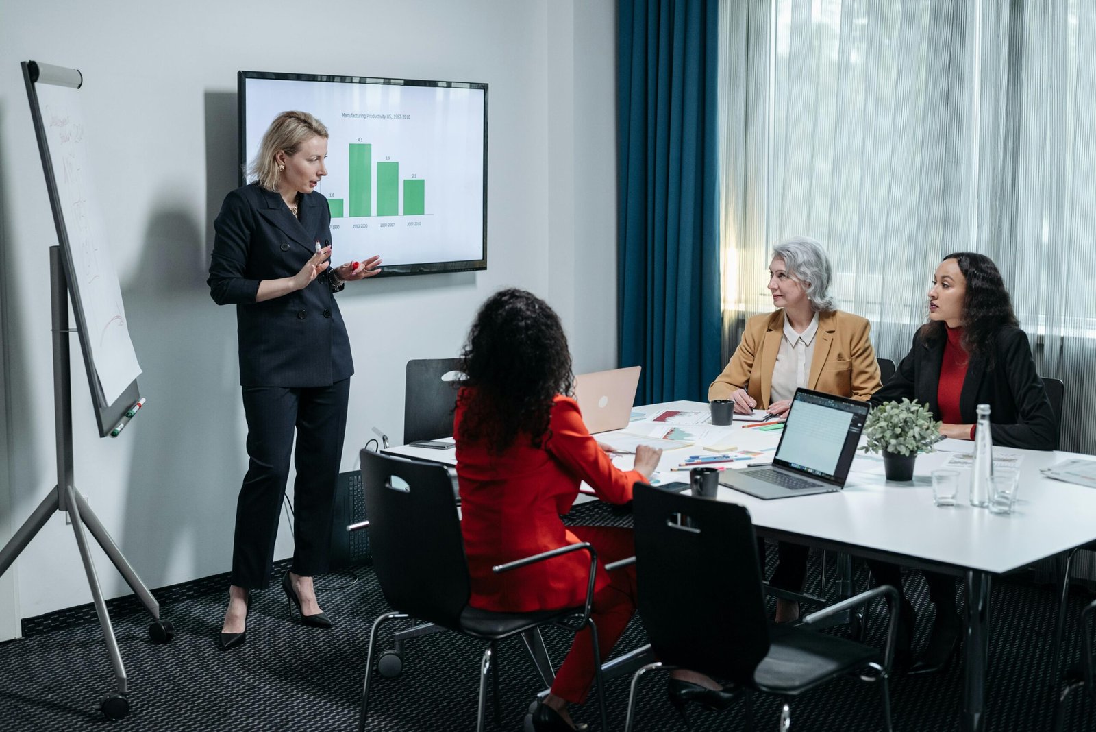 Team collaborating with laptops in a meeting room, illustrating the role of technology in 'Business Development vs Marketing.