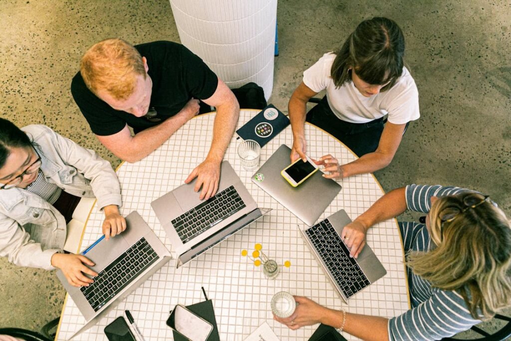 people sitting on a table with laptops - organic business growth