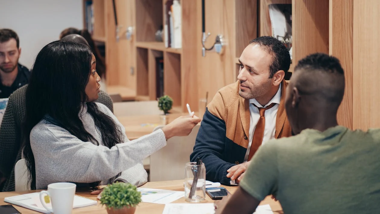 a group of people sitting at a table - growth plans for business