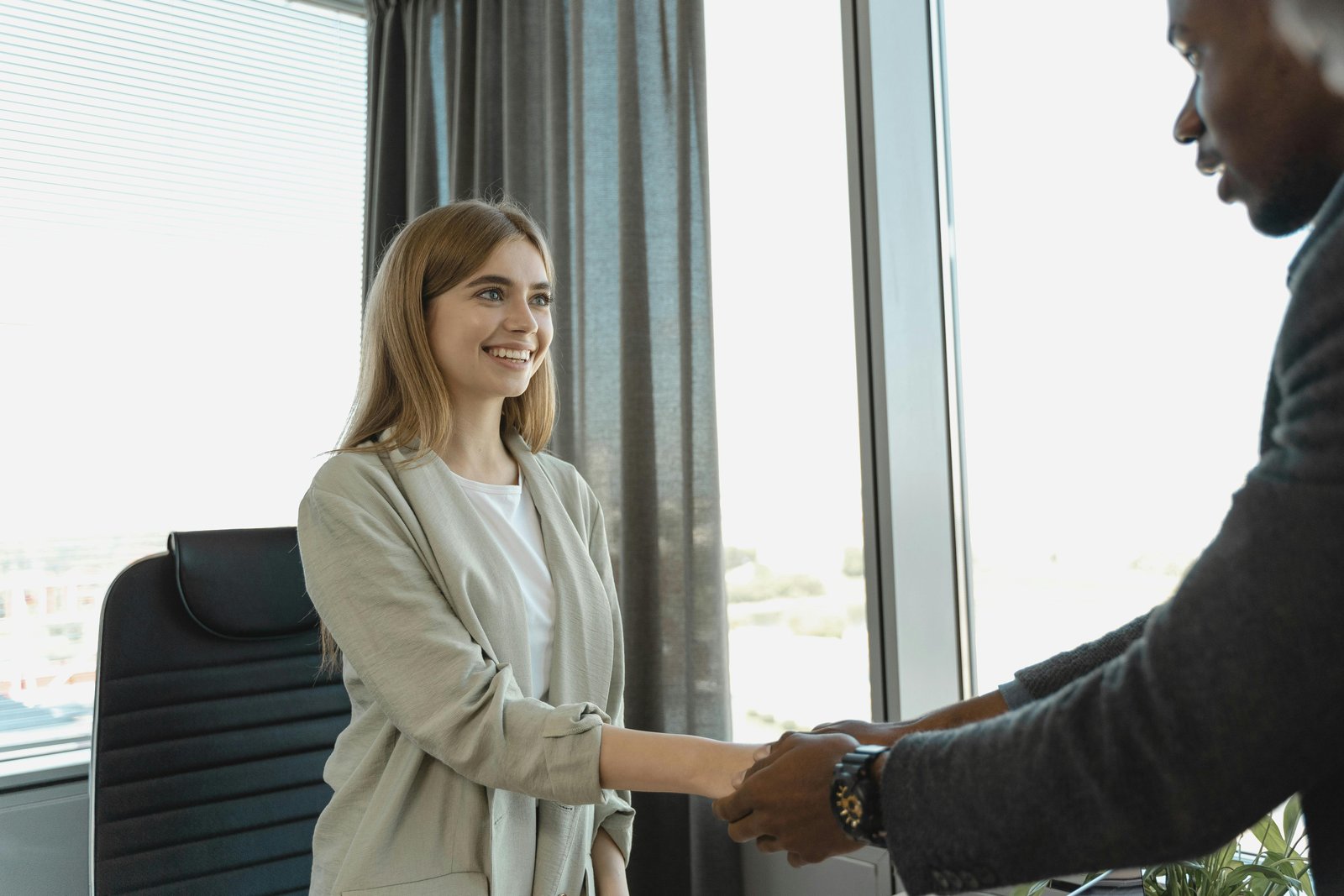 Handshake between colleagues representing 'Equality of Opportunity vs. Outcome.