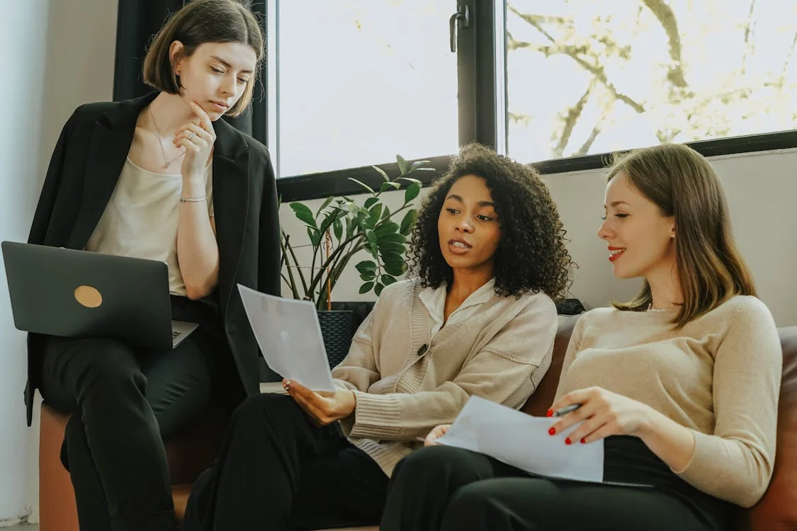 Three professionals in discussion, representing the concept of Cross-Functional Self-Managed Teams.