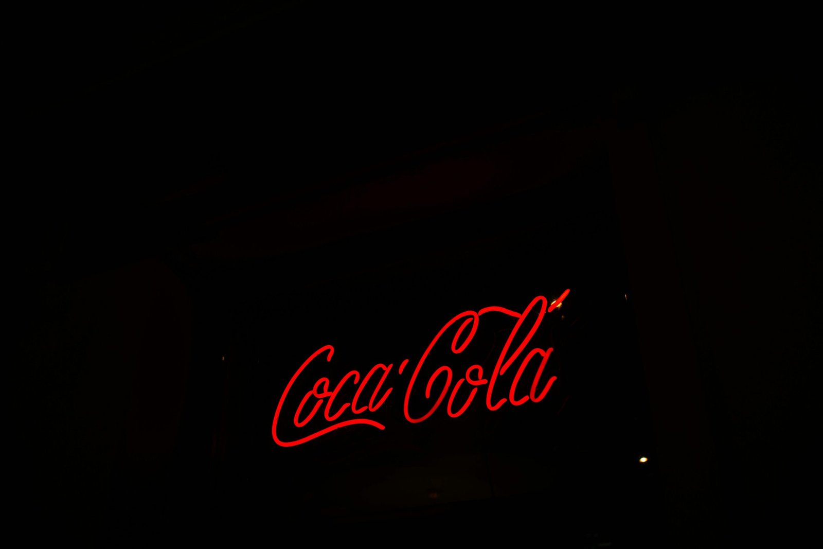 Illuminated Coca-Cola sign symbolizing market penetration in marketing.