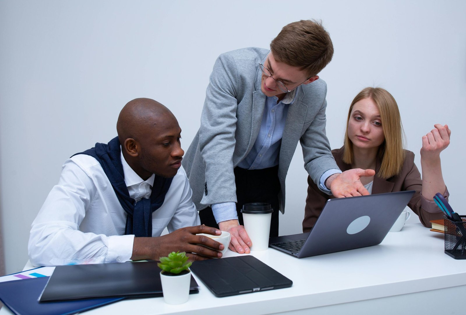 Team discussing a market development strategy around a laptop.