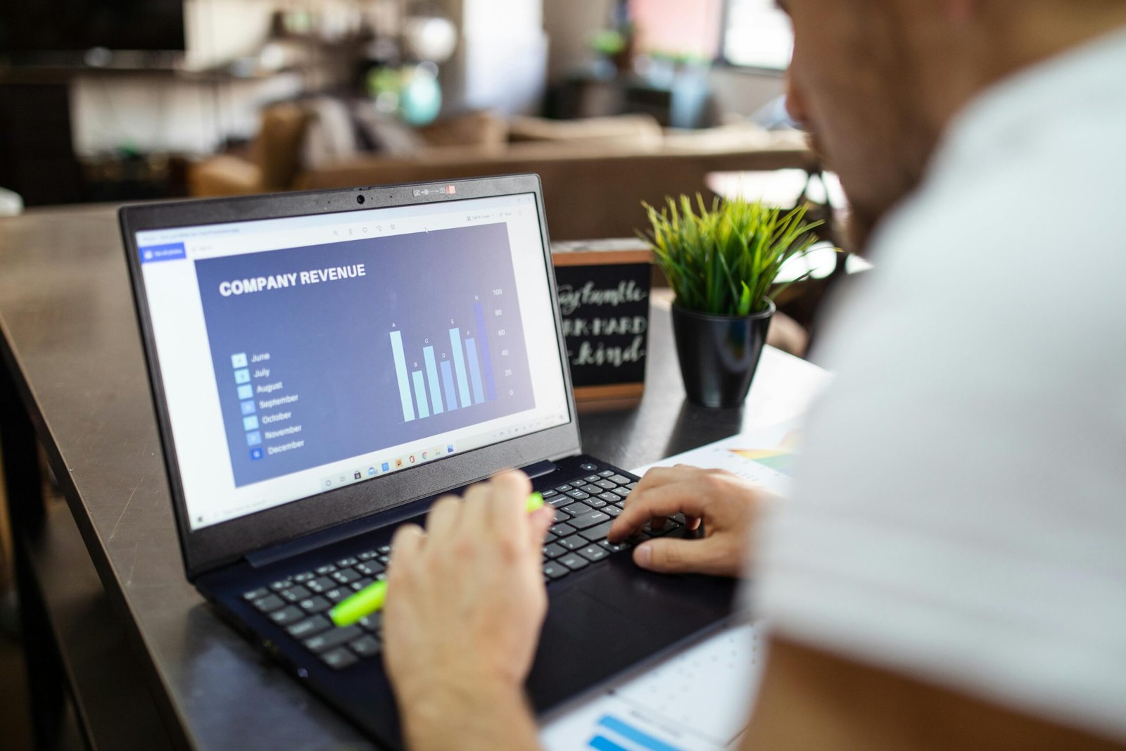 Man analyzing a graph on a laptop screen titled 'Company Revenue' for a discussion on Market Size vs Revenue.