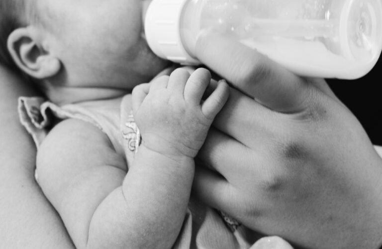 Black and white picture of baby feeding with bottle