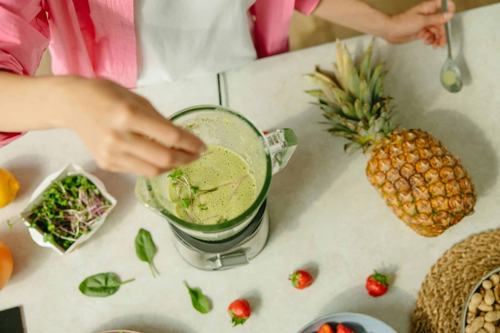 Blended smoothie on a kitchen counter with pineapple and other fruits