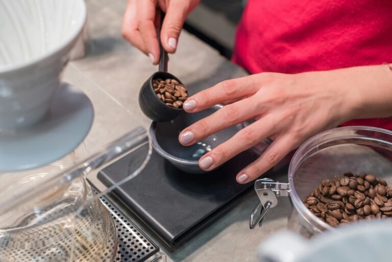 Someone measuring out coffee beans