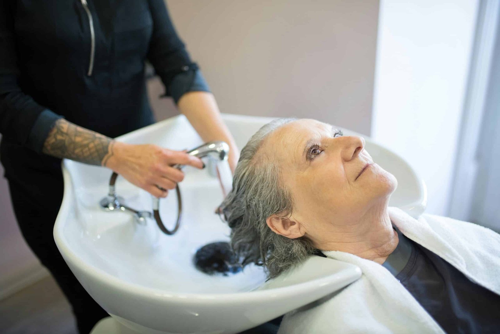 Woman getting her hair washed over a basin