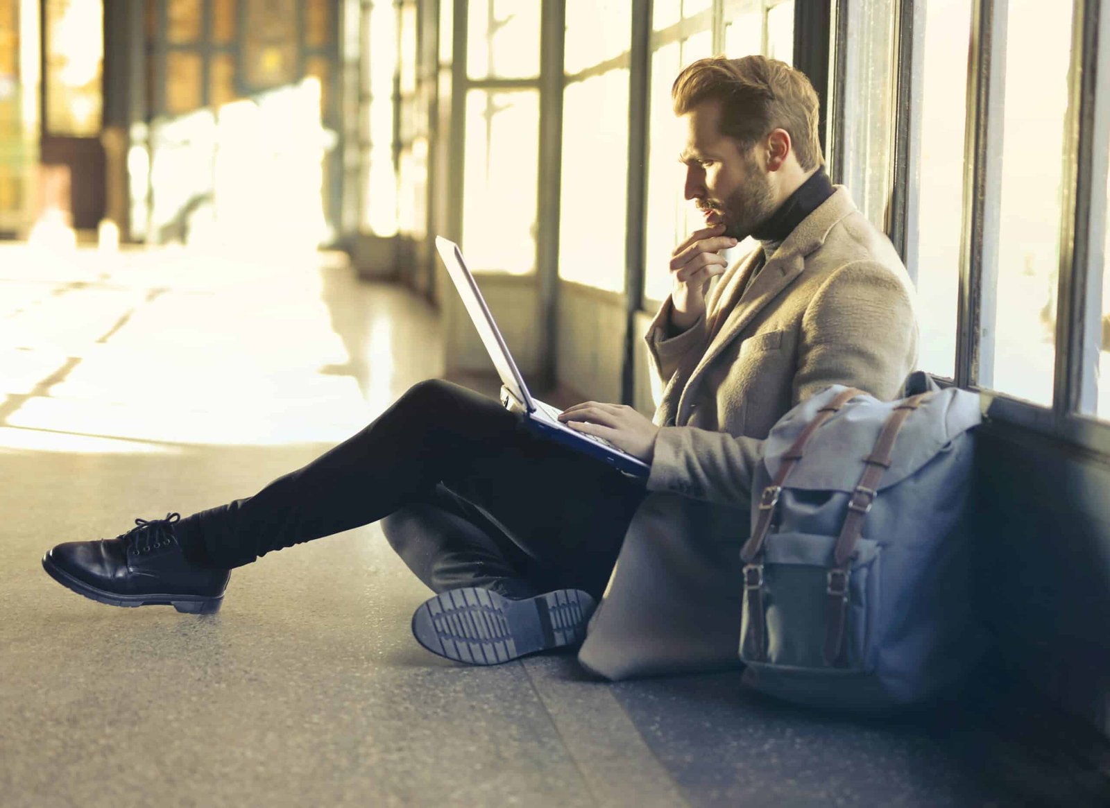 Man sitting on the floor with a laptop open