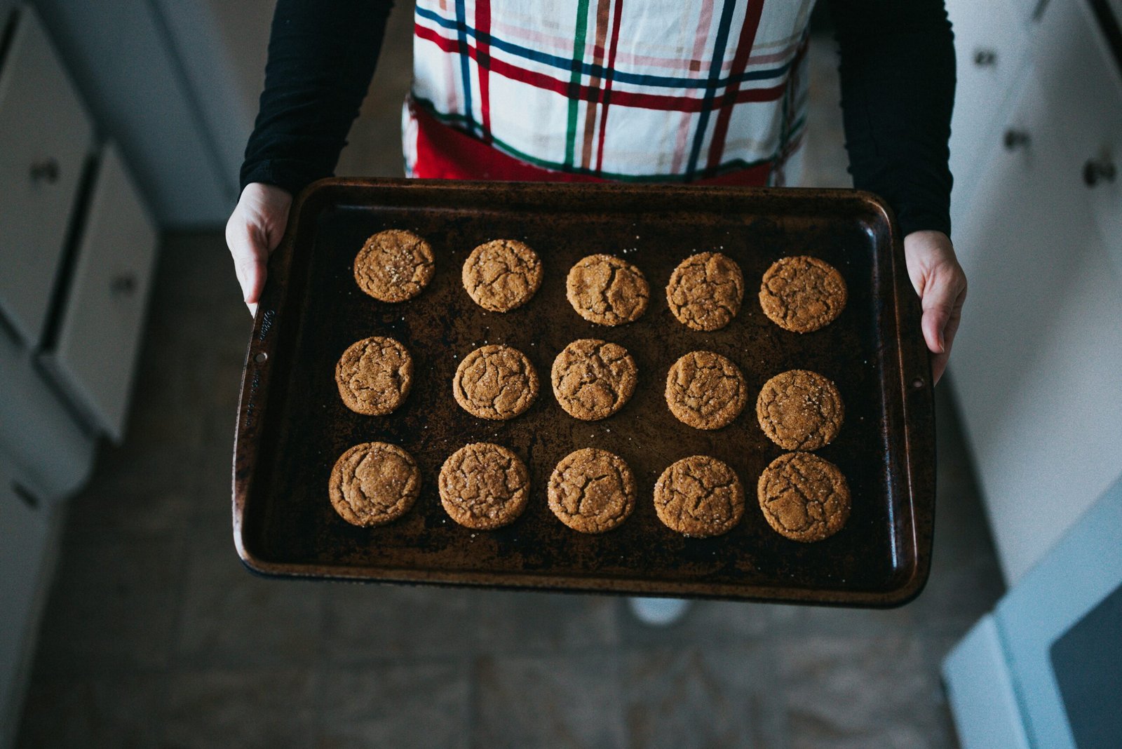 A woman holding a baking tray