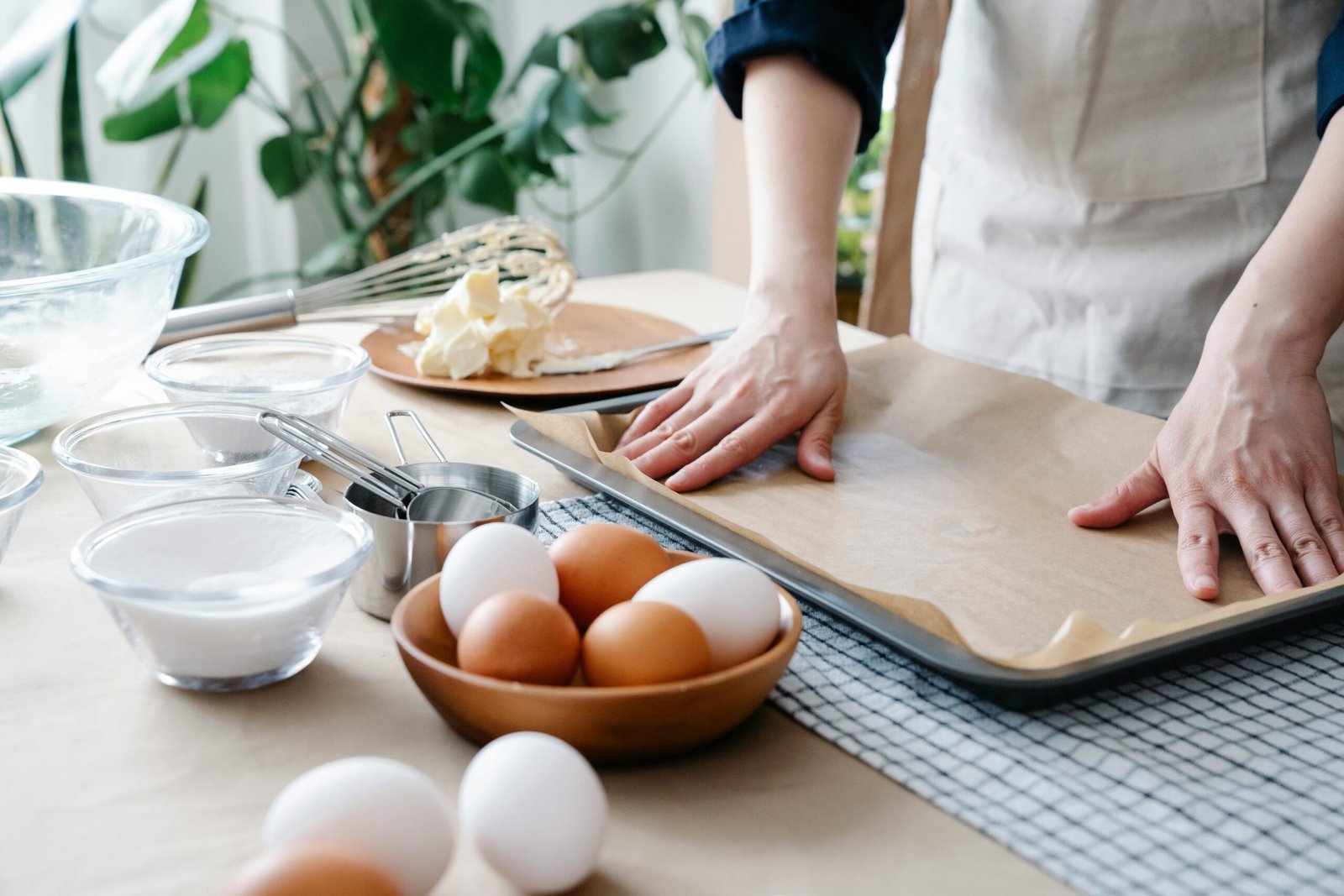 Woman's hand wuth baking ingredients and a baking pan & sheet
