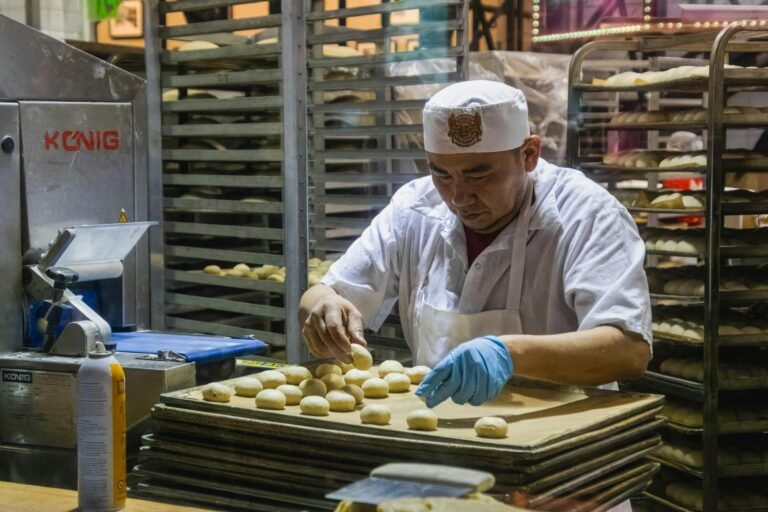Stacks of baking trays with cookie dough on them